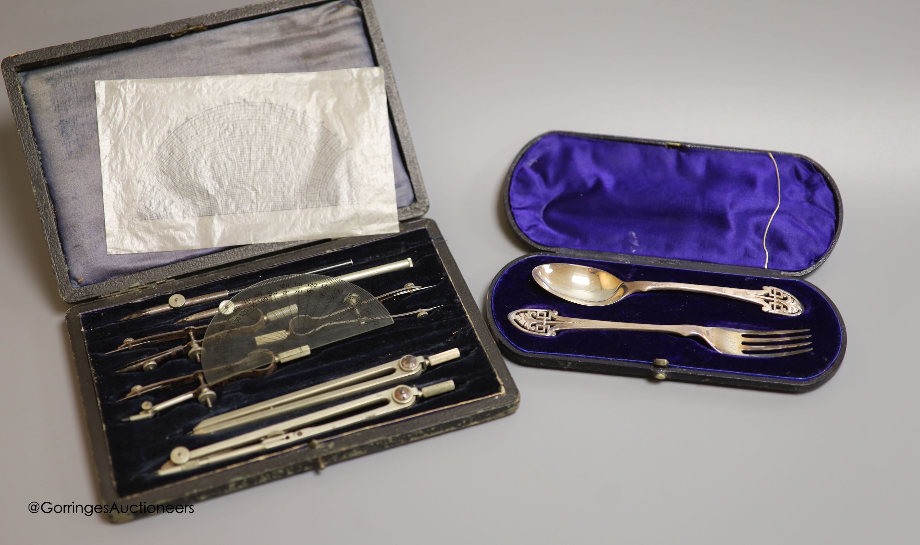 A cased Victorian silver christening spoon and fork, with pierced terminals, Jehoiada Alsop Rhodes, Sheffield, 1873 and a draughtsman's set.